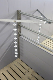 Die robusten Halter für Beschäftigungsmaterial bieten Befestigungsmöglichkeit für Spielmaterial wie Beißketten, Beißsterne oder Beißkugeln. Hier im Bild die klassische Installation in zwei Buchten mit Befestigung an der Abteilwand.